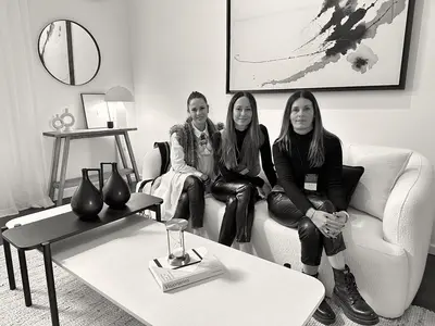 Las tres integrantes de BeHome sentadas en un sillón blanco. Foto en blanco y negro.